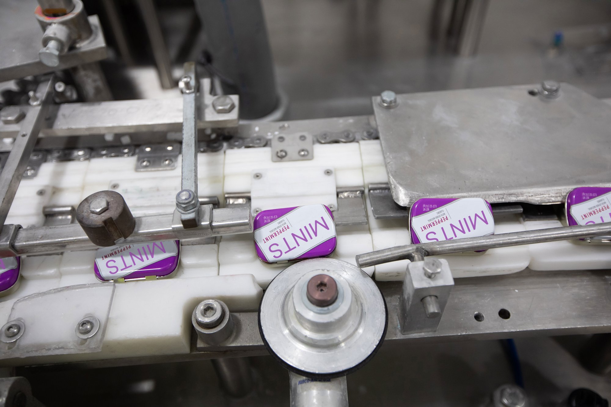 Tins of mints on a conveyor belt